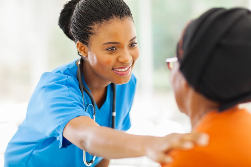 22198041 Caring African Medical Nurse Comforting Senior Patient In